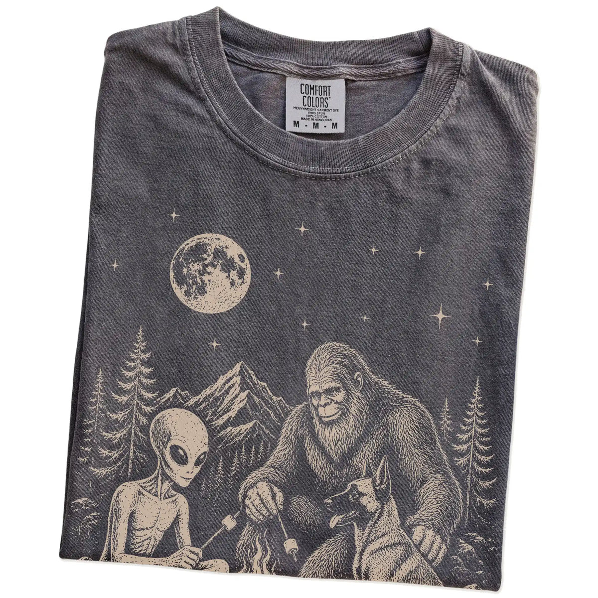 Folded Pepper Comfort Colors® T-shirt showing Belgian Malinois camping with Bigfoot and an alien