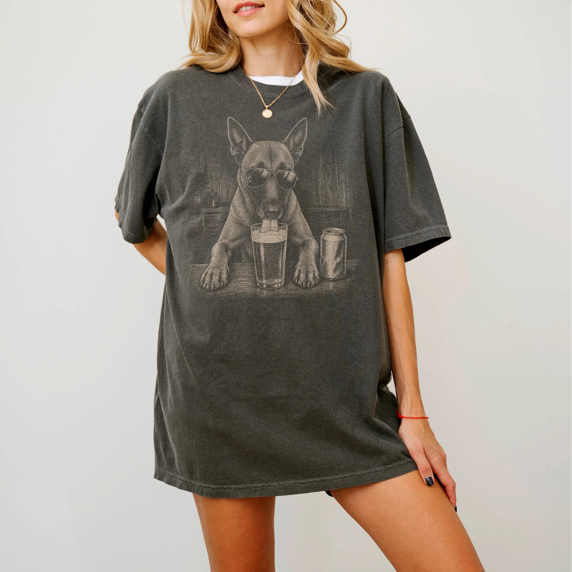 Model wearing a Pepper Comfort Colors® t-shirt with Belgian Malinois sneaking a drink from a pint