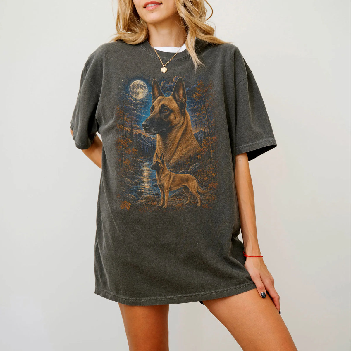 Model wearing a Pepper Comfort Colors® t-shirt featuring Belgian Malinois in a moonlit fall forest