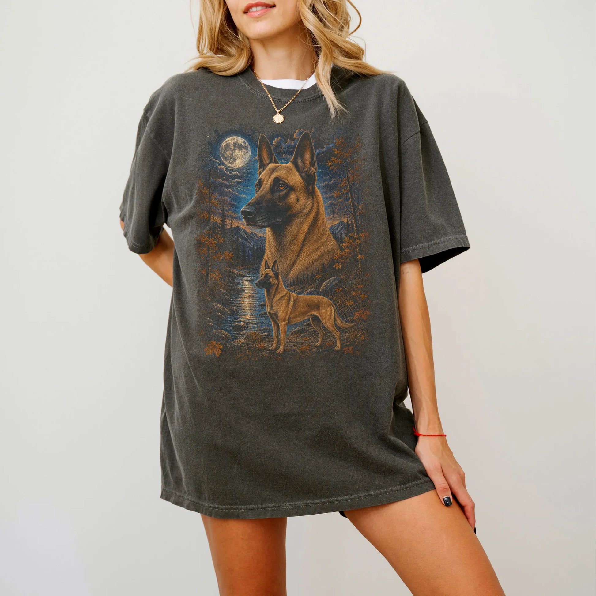 Model wearing a Pepper Comfort Colors® t-shirt featuring Belgian Malinois in a moonlit fall forest