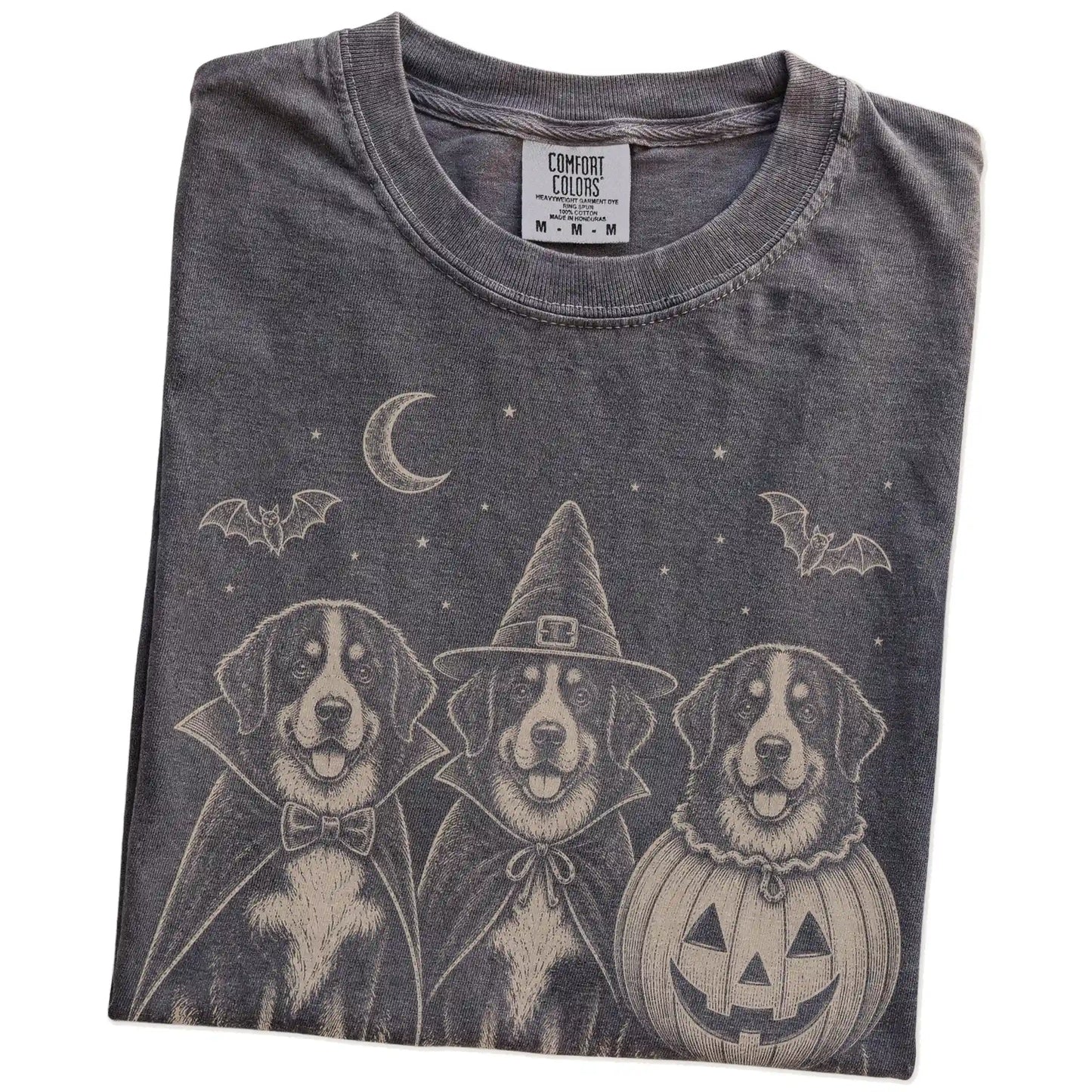 Folded Pepper Comfort Colors® T-shirt showing three Bernese Mountain Dog dogs dressed for Halloween beneath bats and a cresce