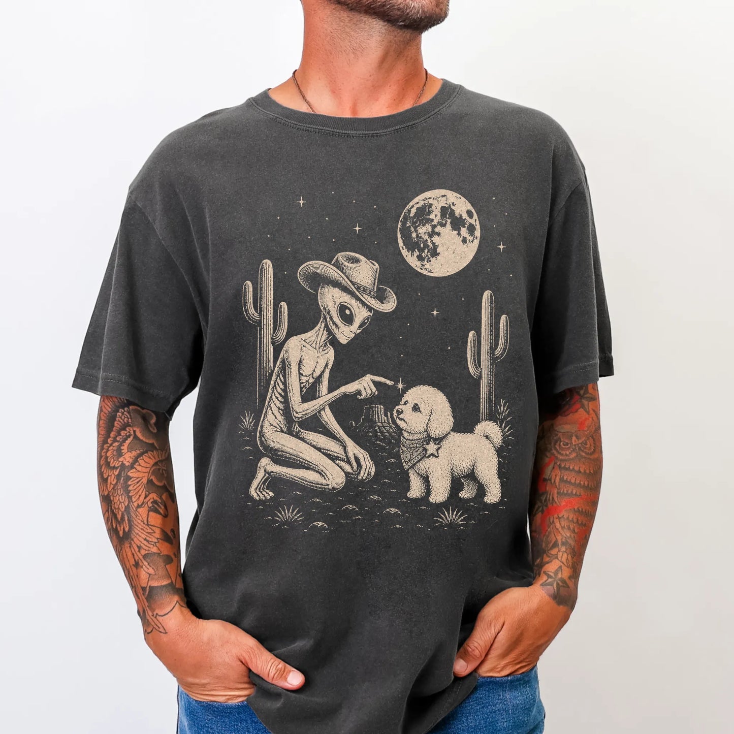 Model wearing a Pepper Comfort Colors® T-shirt with cowboy alien fist-bumping a bichon frise beneath the moon
