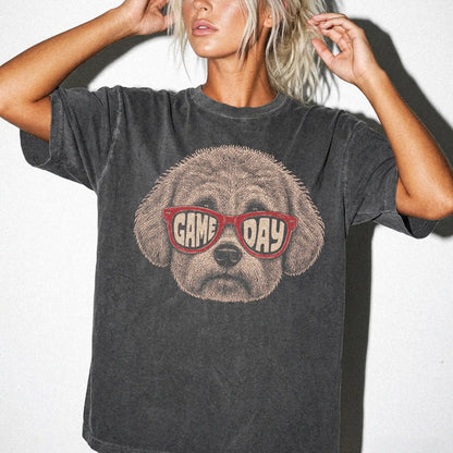 Model wearing a Pepper Comfort Colors® T-shirt with bichon frise wearing red game day sunglasses