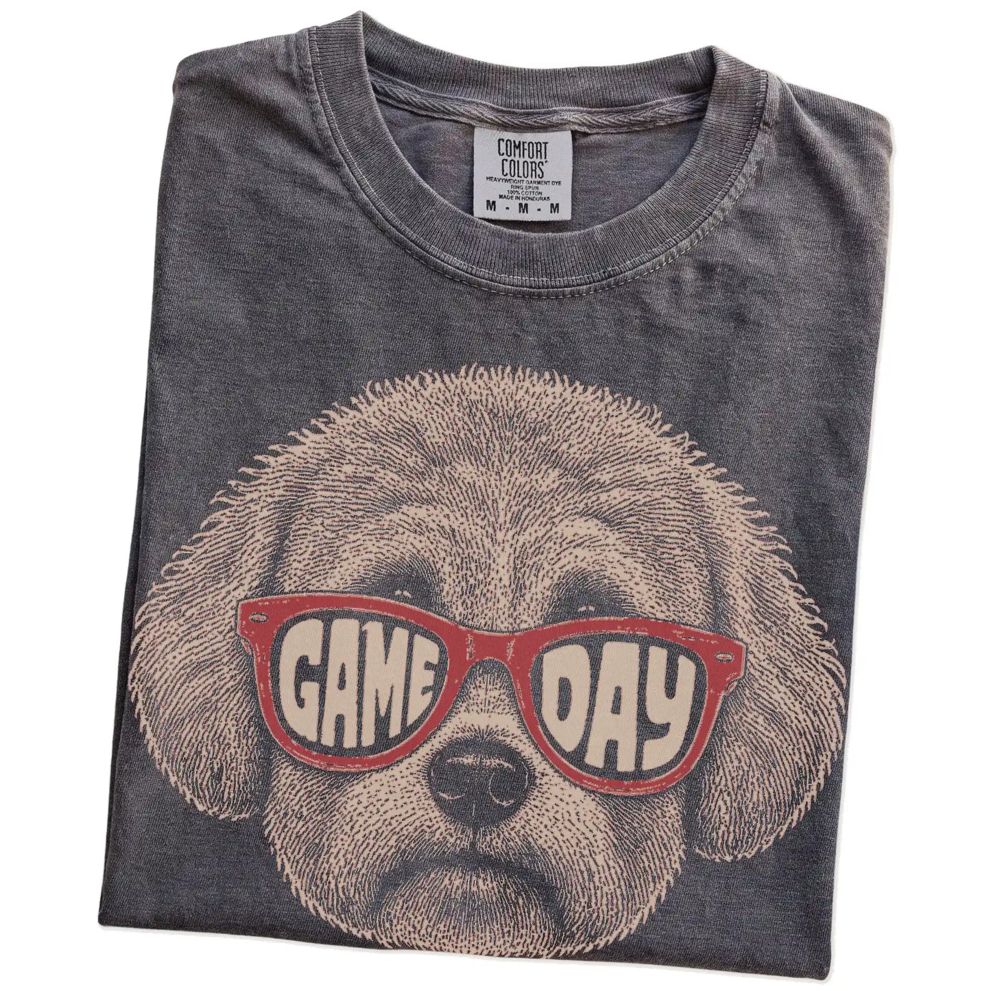 Folded Pepper Comfort Colors® T-shirt showing bichon frise wearing red game day sunglasses