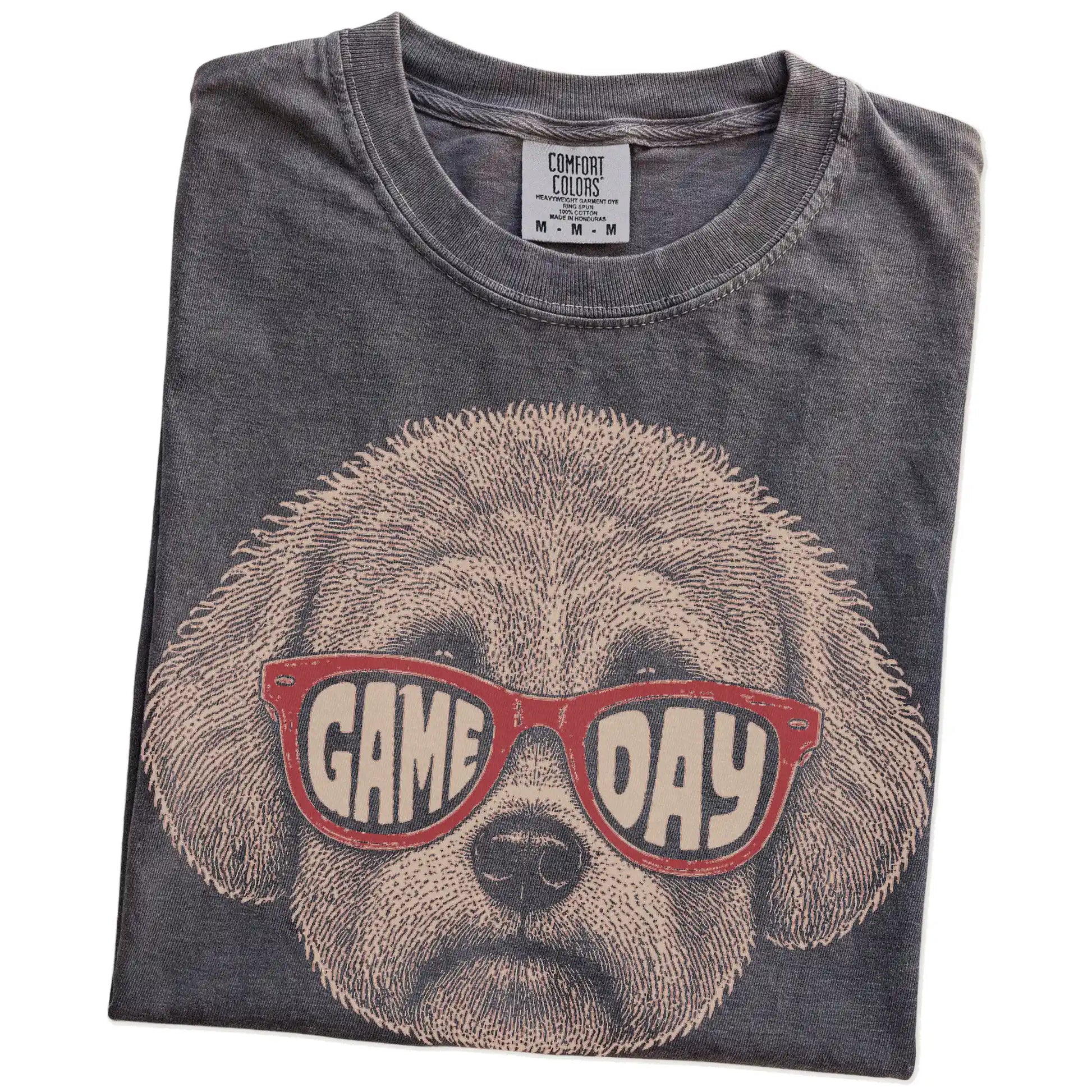 Folded Pepper Comfort Colors® T-shirt showing bichon frise wearing red game day sunglasses
