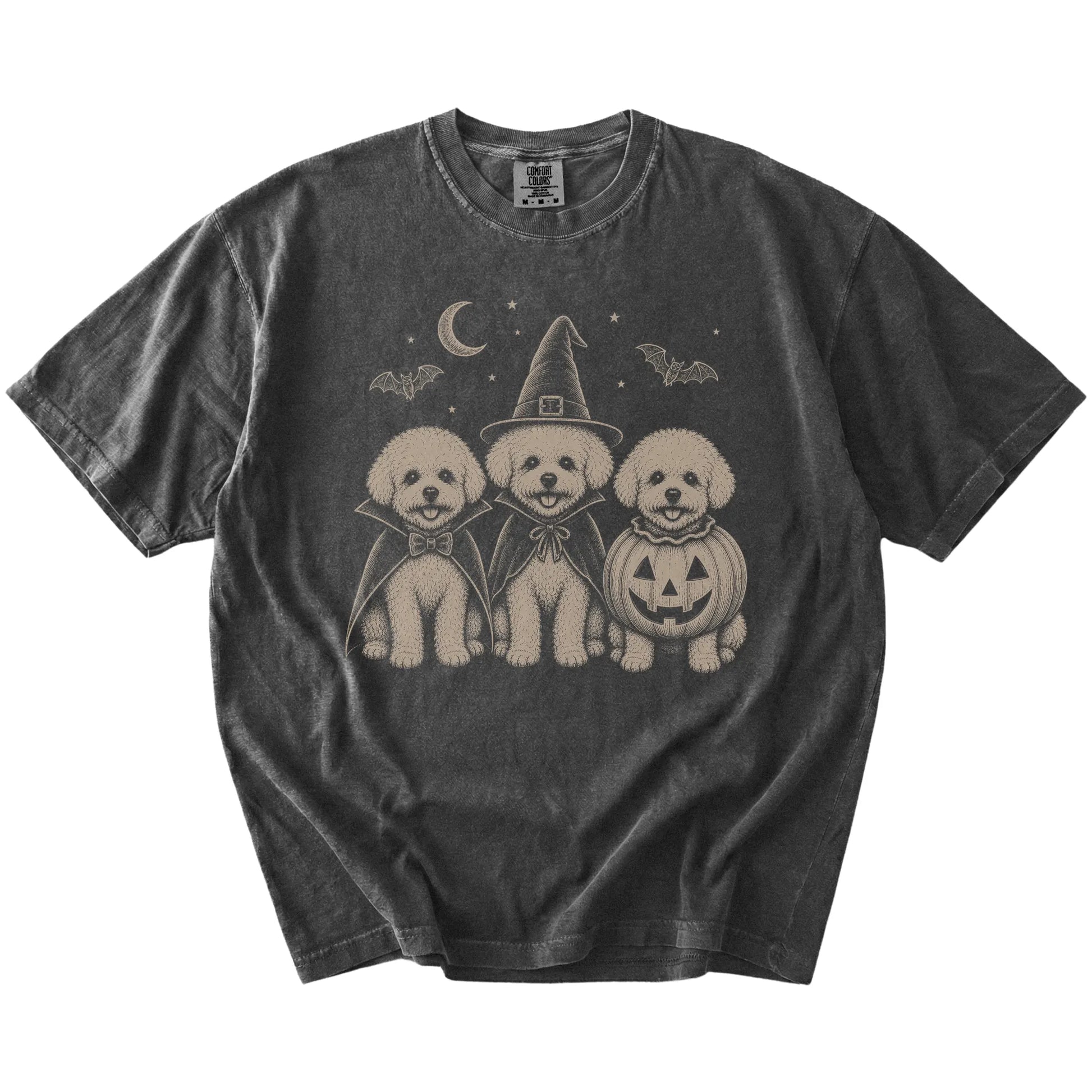 Three Bichon Frise dogs dressed for Halloween beneath bats and a crescent moon on a Pepper Comfort Colors® T-shirt