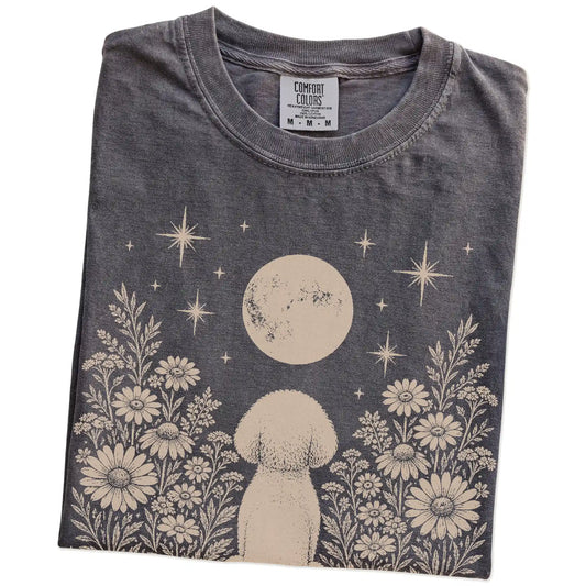 Folded Pepper Comfort Colors® T-shirt showing Bichon Frise beneath a wildflower moon