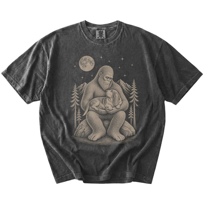 Bigfoot holding a Basset Hound on a Pepper Comfort Colors® T-shirt