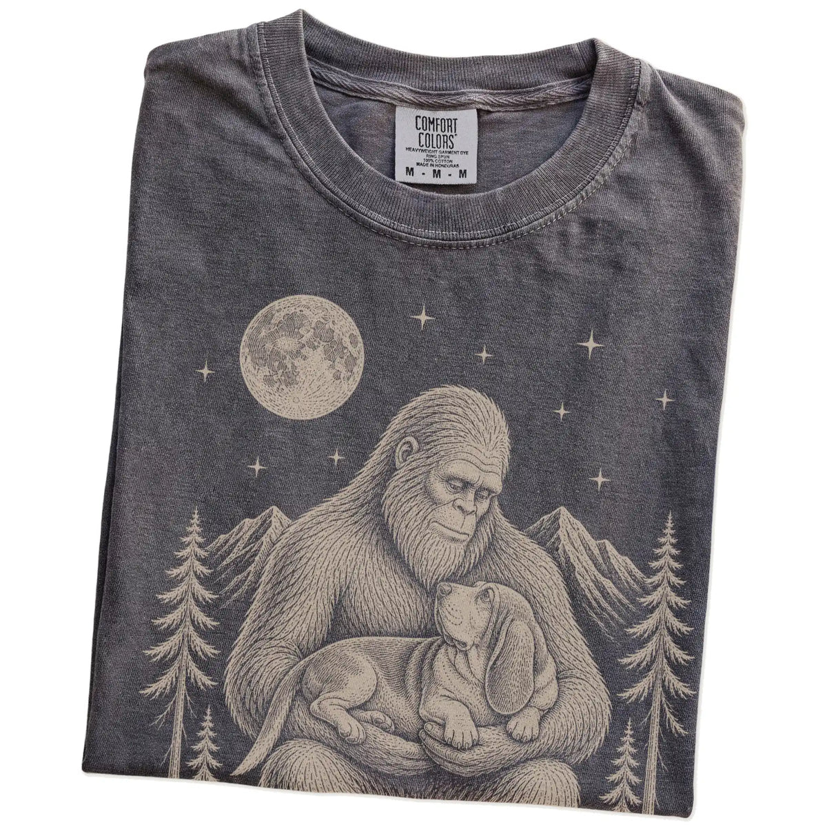 Folded Pepper Comfort Colors® T-shirt showing Bigfoot holding a Basset Hound