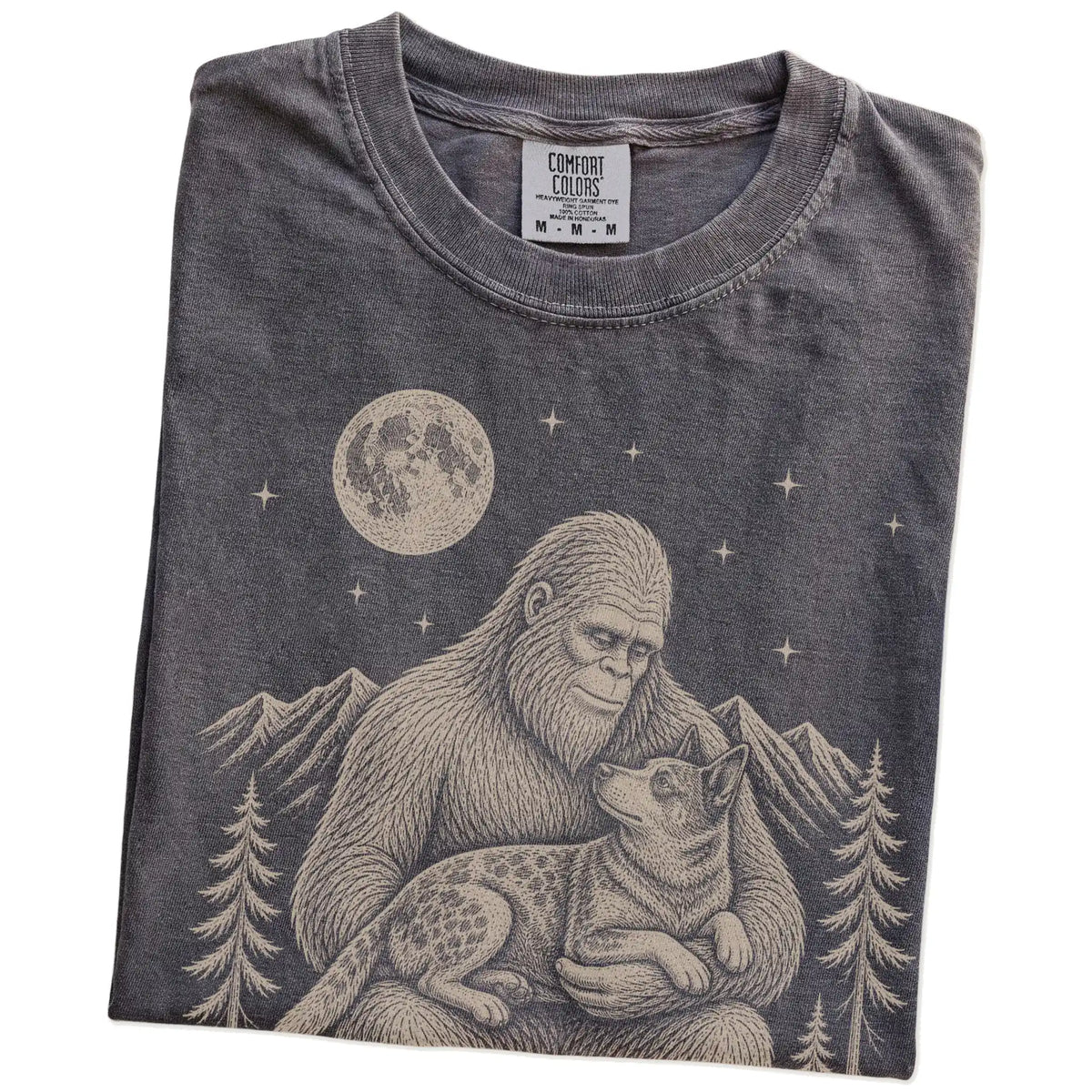 Folded Pepper Comfort Colors® T-shirt showing Bigfoot holding a Blue Heeler
