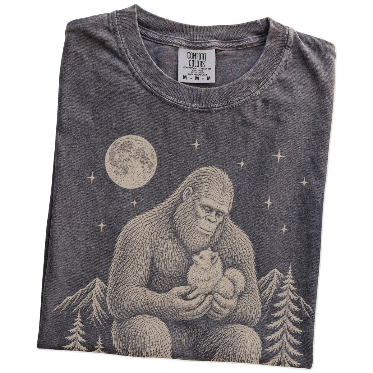 Folded Pepper Comfort Colors® T-shirt showing Bigfoot holding a Pomeranian