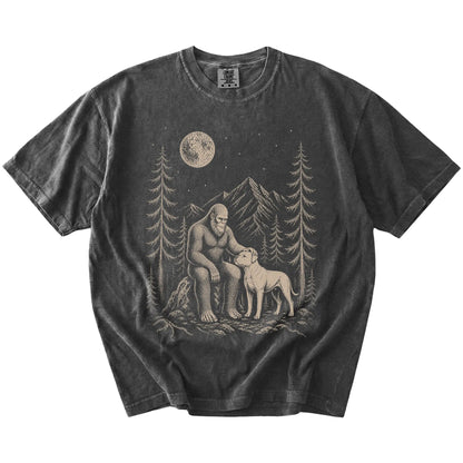 Bigfoot petting a American Bulldog beneath the moon in a pine forest on a Pepper Comfort Colors® T-shirt