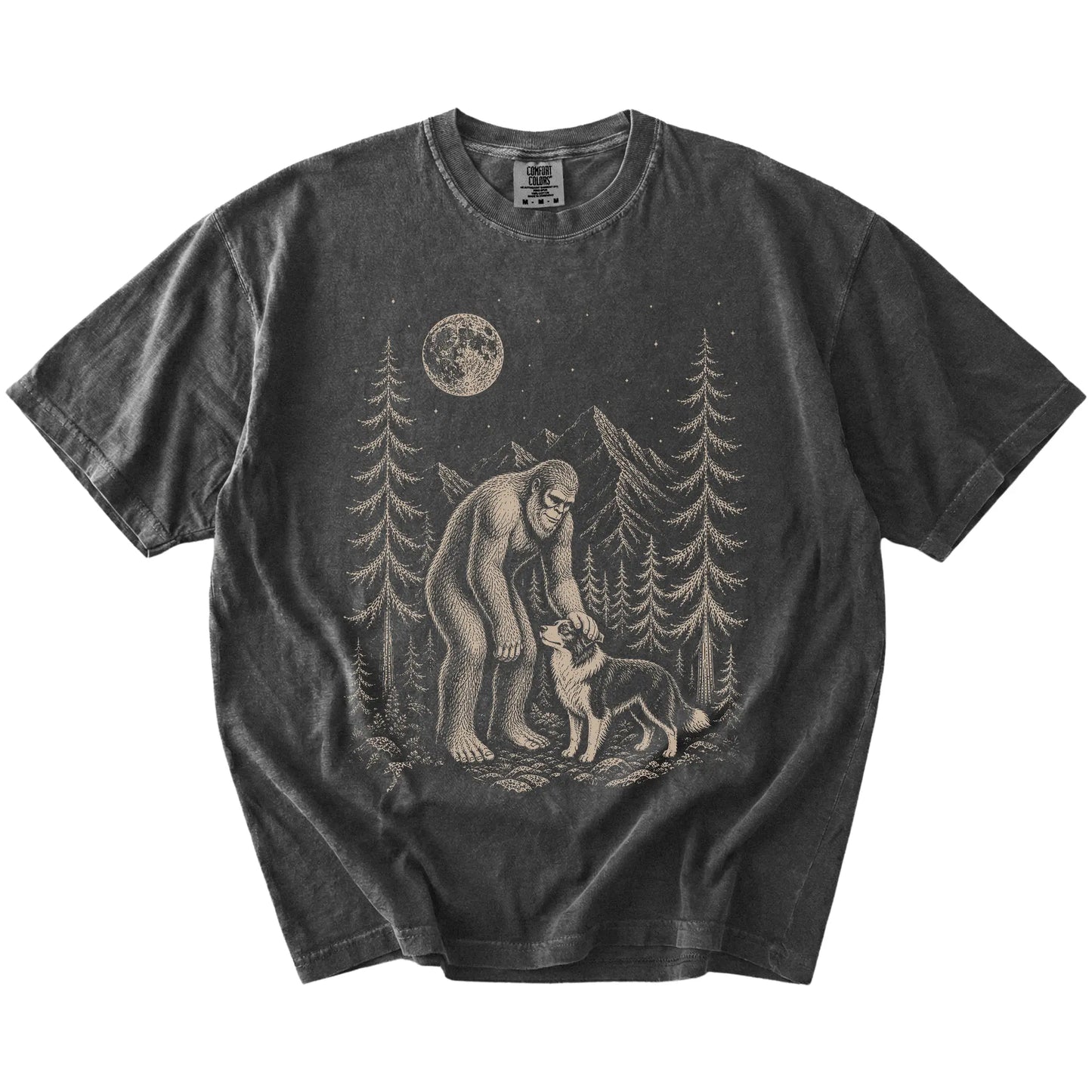 Bigfoot petting a Border Collie beneath the moon in a pine forest on a Pepper Comfort Colors® T-shirt