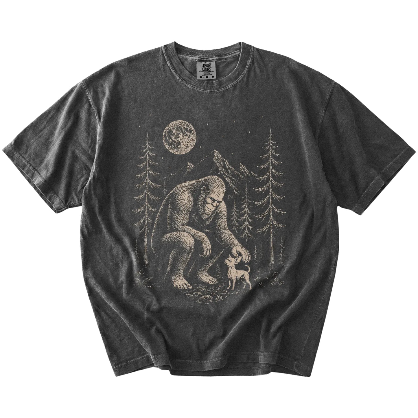 Bigfoot petting a Chihuahua beneath the moon in a pine forest on a Pepper Comfort Colors® T-shirt