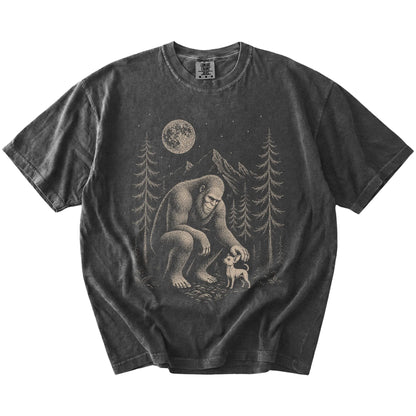 Bigfoot petting a Chihuahua beneath the moon in a pine forest on a Pepper Comfort Colors® T-shirt