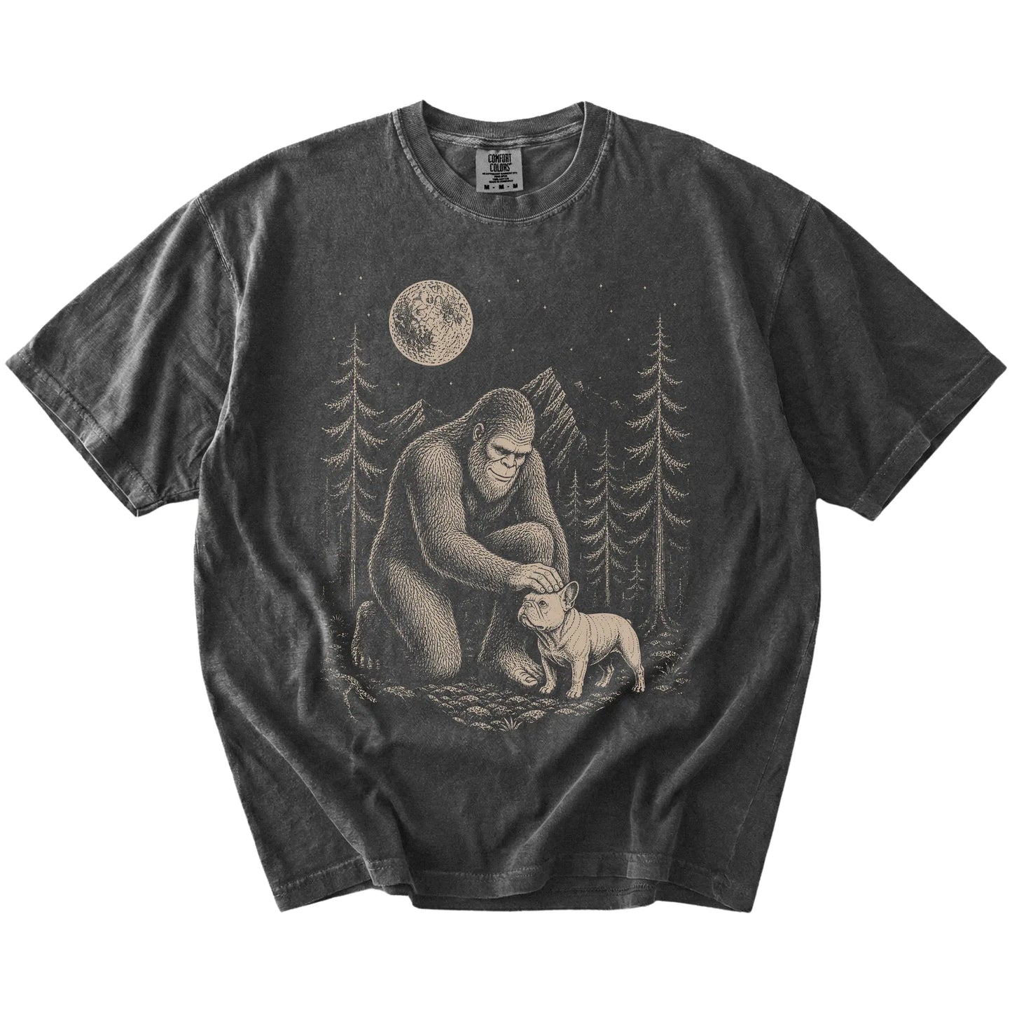 Bigfoot petting a French Bulldog beneath the moon in a pine forest on a Pepper Comfort Colors® T-shirt