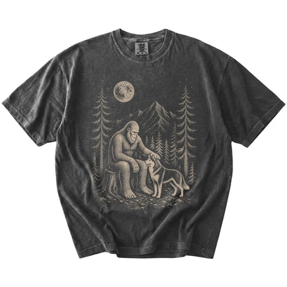 Bigfoot petting a Husky beneath the moon in a pine forest on a Pepper Comfort Colors® T-shirt