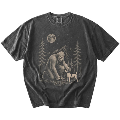 Bigfoot petting a Jack Russell beneath the moon in a pine forest on a Pepper Comfort Colors® T-shirt