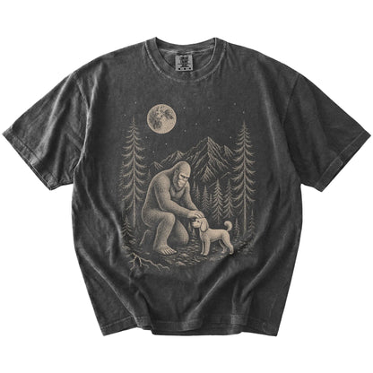 Bigfoot petting a Poodle beneath the moon in a pine forest on a Pepper Comfort Colors® T-shirt