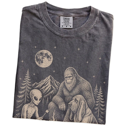 Folded Pepper Comfort Colors® T-shirt showing Bloodhound camping with Bigfoot and an alien