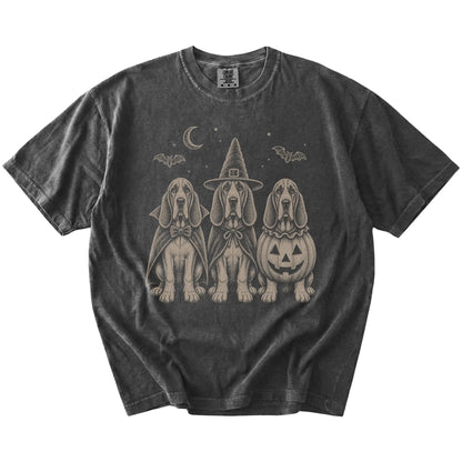 Three Bloodhound dogs dressed for Halloween beneath bats and a crescent moon on a Pepper Comfort Colors® T-shirt
