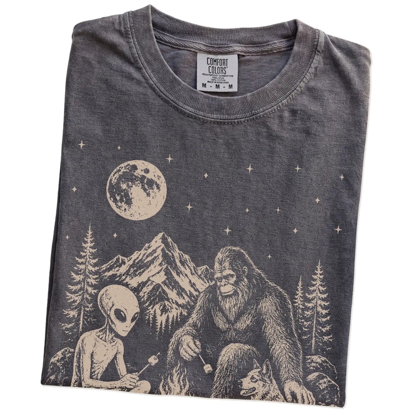 Folded Pepper Comfort Colors® T-shirt showing Blue Heeler camping with Bigfoot and an alien