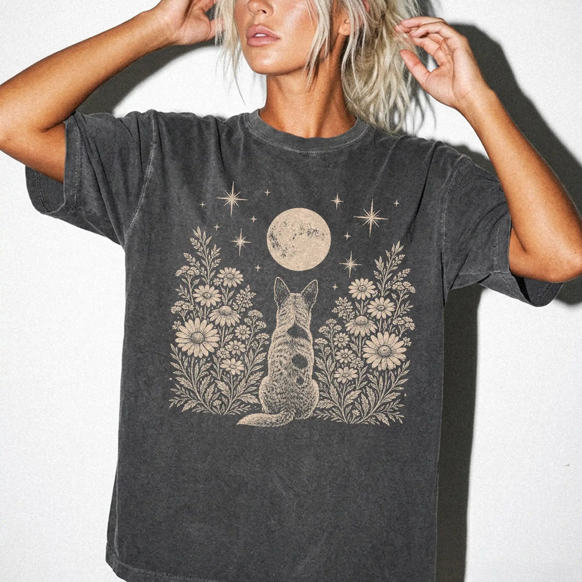 Model wearing a Pepper Comfort Colors® T-shirt featuring Blue Heeler beneath a wildflower moon
