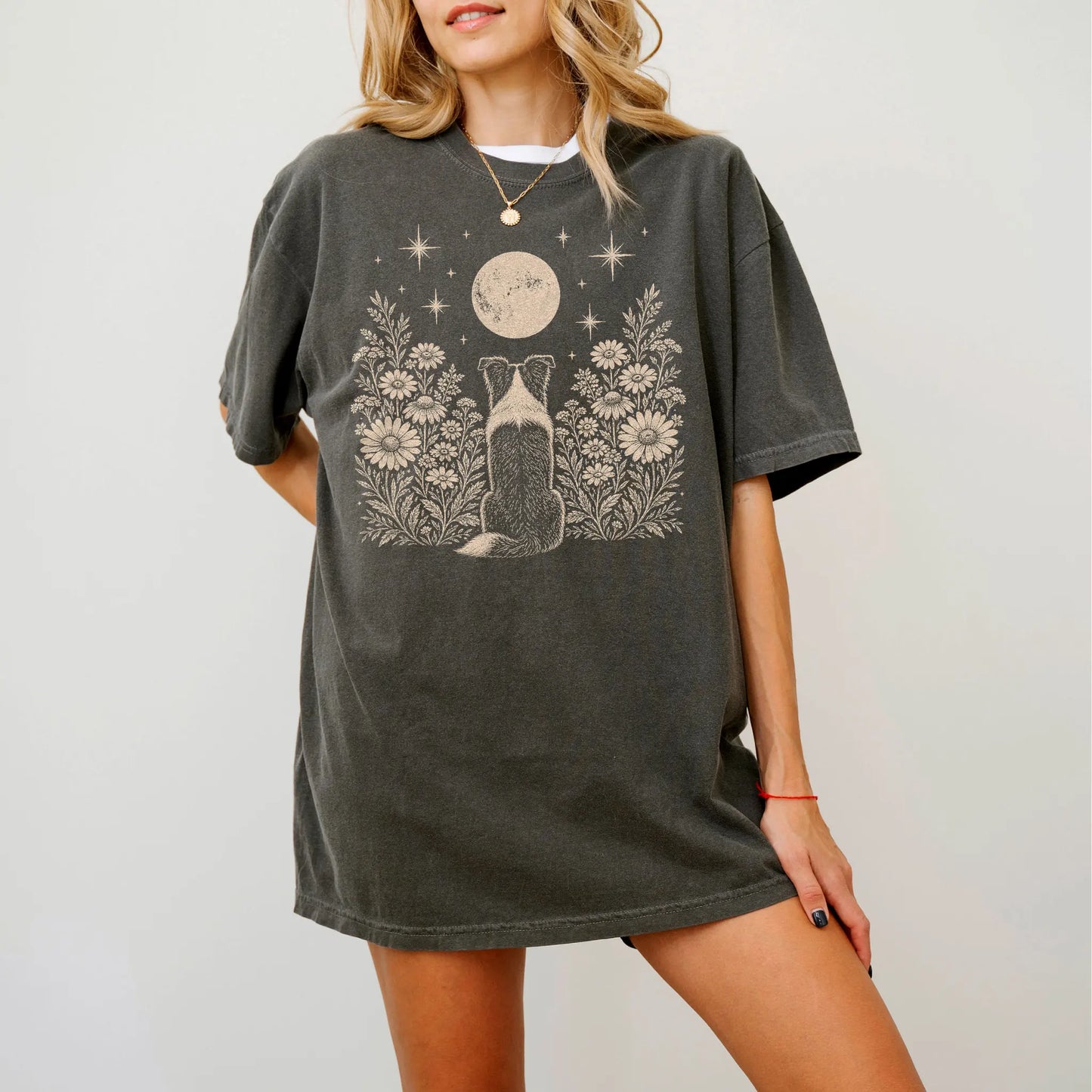 Model wearing a Pepper Comfort Colors® T-shirt featuring Border Collie beneath a wildflower moon