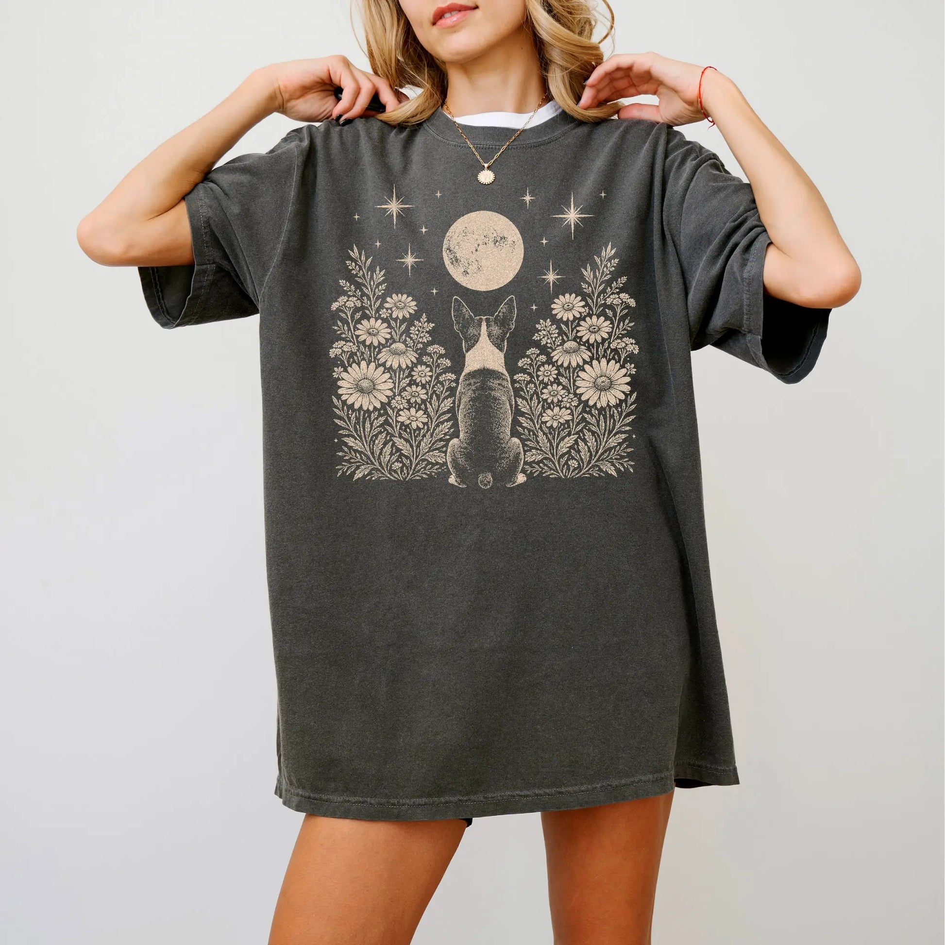 Model wearing a Pepper Comfort Colors® T-shirt featuring Boston Terrier beneath a wildflower moon