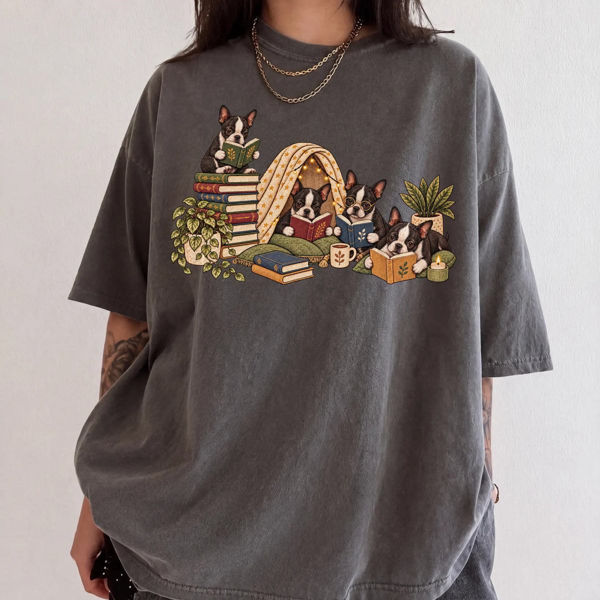 Boston Terrier puppies reading books in a cozy blanket fort on a Pepper T-shirt worn by a model