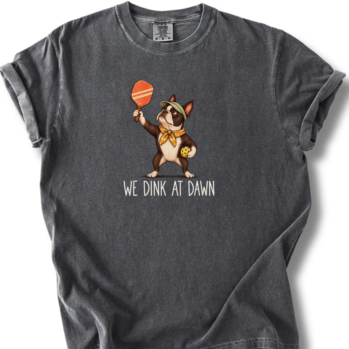 Boston Terrier with a pickleball paddle and ball on a Pepper Comfort Colors® T-shirt with We Dink at Dawn text
