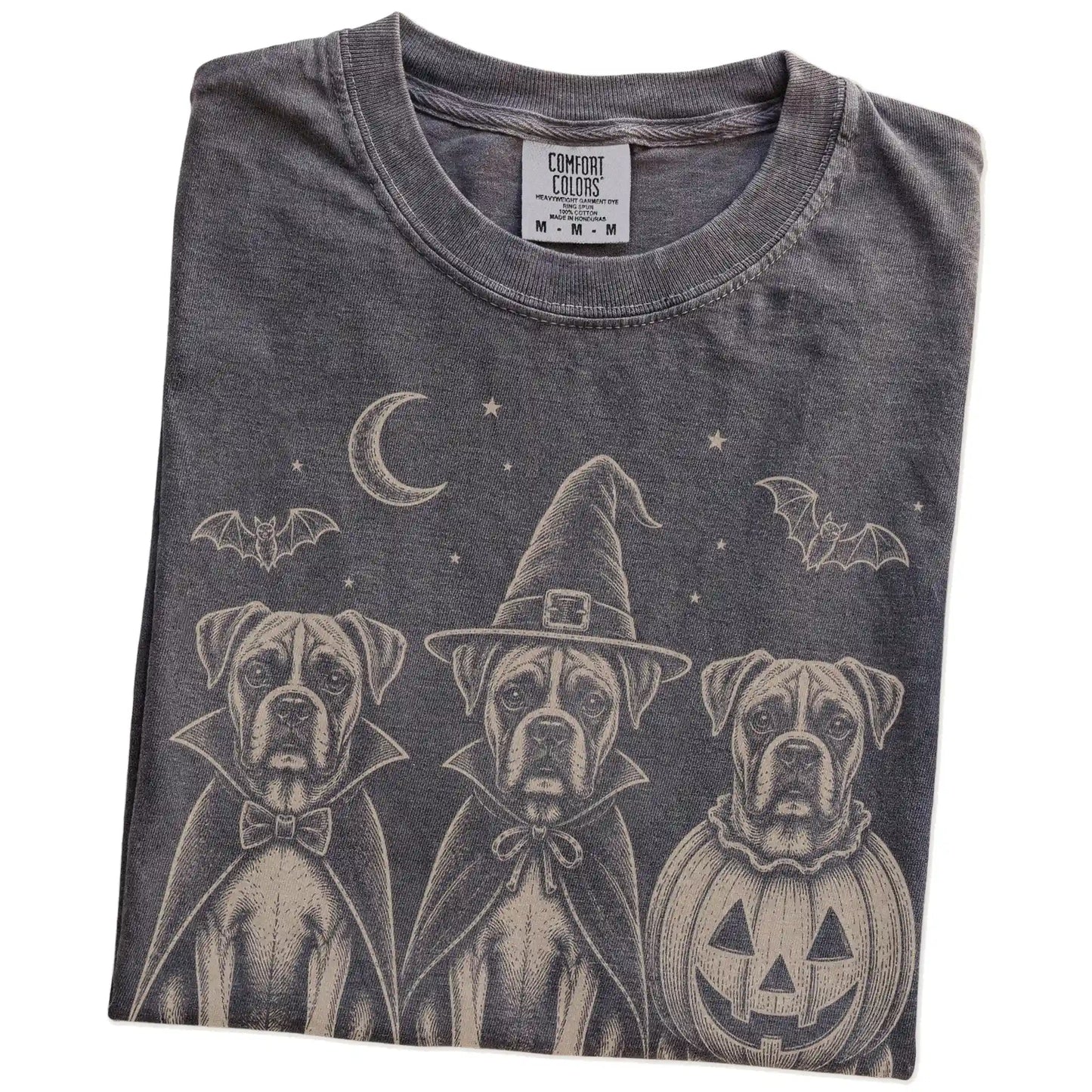 Folded Pepper Comfort Colors® T-shirt showing three Boxer dogs dressed for Halloween beneath bats and a crescent moon
