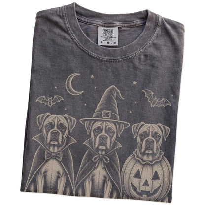 Folded Pepper Comfort Colors® T-shirt showing three Boxer dogs dressed for Halloween beneath bats and a crescent moon