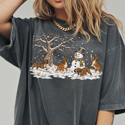 Boxer puppies playing in snow with a snowman on a Pepper T-shirt worn by a model