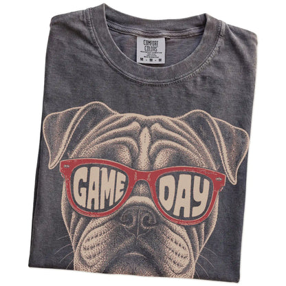 Folded Pepper Comfort Colors® T-shirt showing bulldog wearing red game day sunglasses