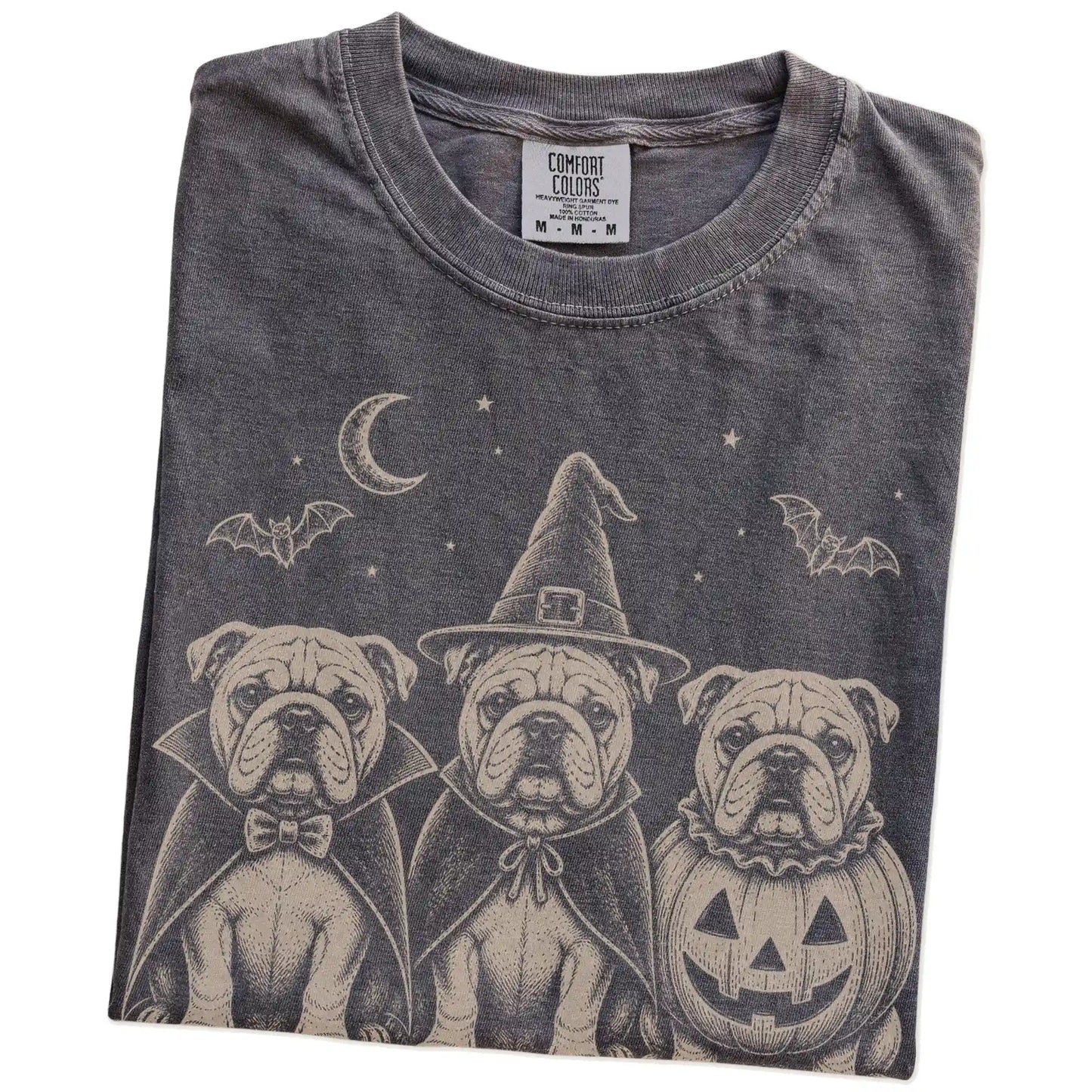 Folded Pepper Comfort Colors® T-shirt showing three Bulldog dogs dressed for Halloween beneath bats and a crescent moon