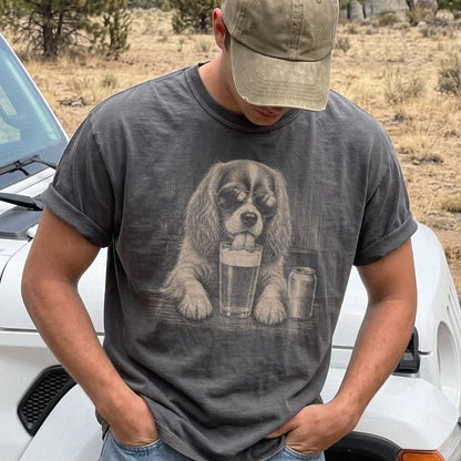 Model wearing a Pepper Comfort Colors® t-shirt with Cavalier King Charles Spaniel sneaking a drink from a pint