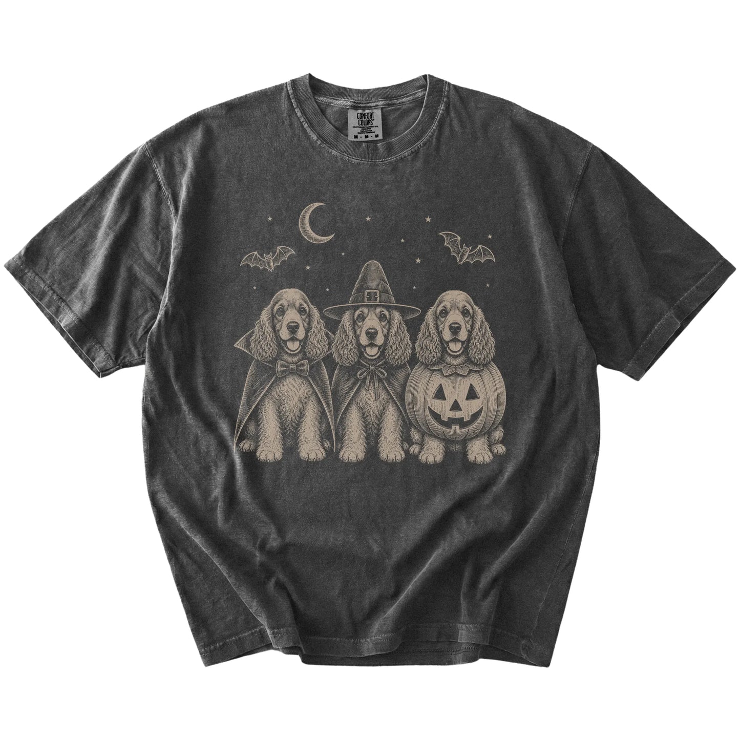 Three Cocker Spaniel dogs dressed for Halloween beneath bats and a crescent moon on a Pepper Comfort Colors® T-shirt
