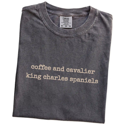 Folded Pepper Comfort Colors® T-shirt showing “coffee and cavalier king charles spaniels” retro text