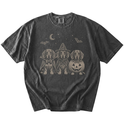 Three Dachshund dogs dressed for Halloween beneath bats and a crescent moon on a Pepper Comfort Colors® T-shirt