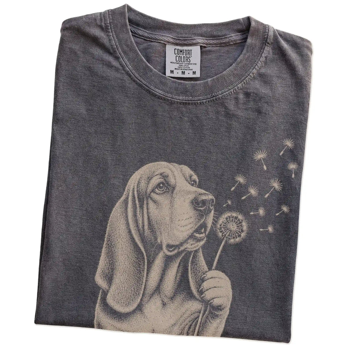 Folded Pepper Comfort Colors® T-shirt showing Basset Hound portrait with drifting dandelion seeds