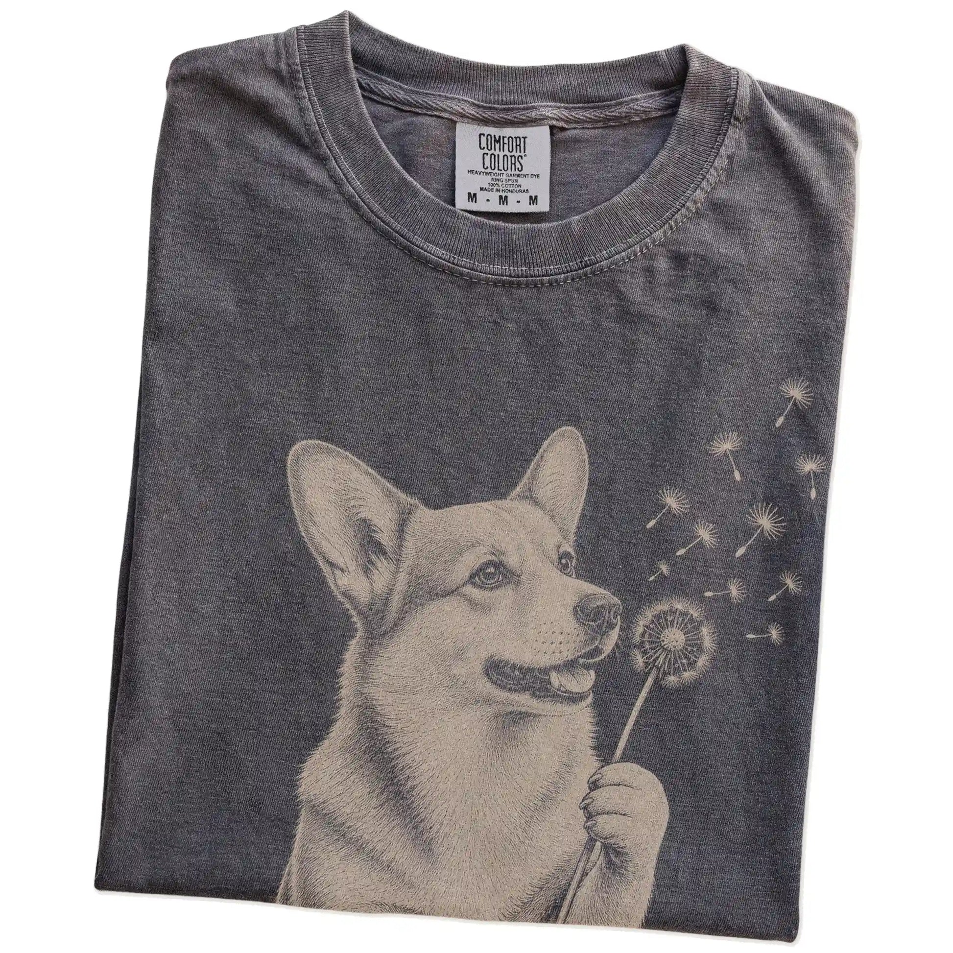 Folded Pepper Comfort Colors® T-shirt showing Corgi portrait with drifting dandelion seeds