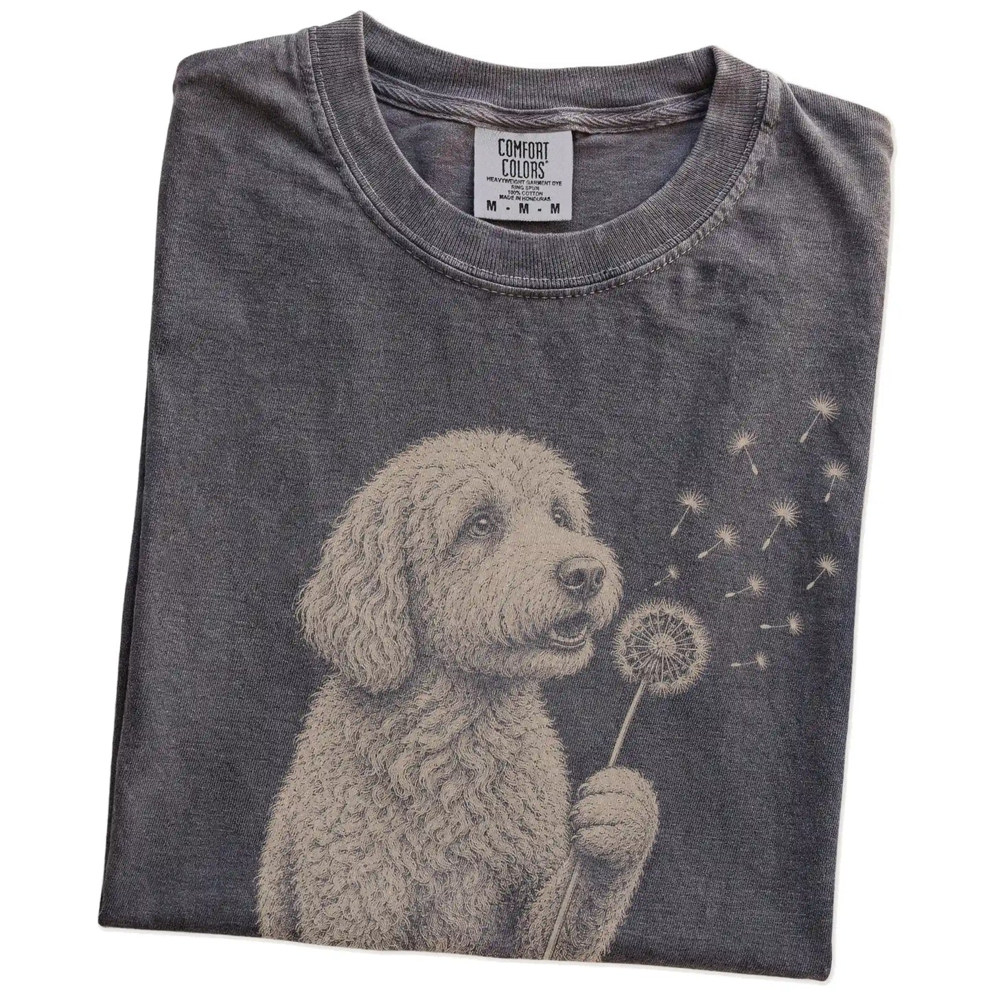 Folded Pepper Comfort Colors® T-shirt showing Goldendoodle portrait with drifting dandelion seeds