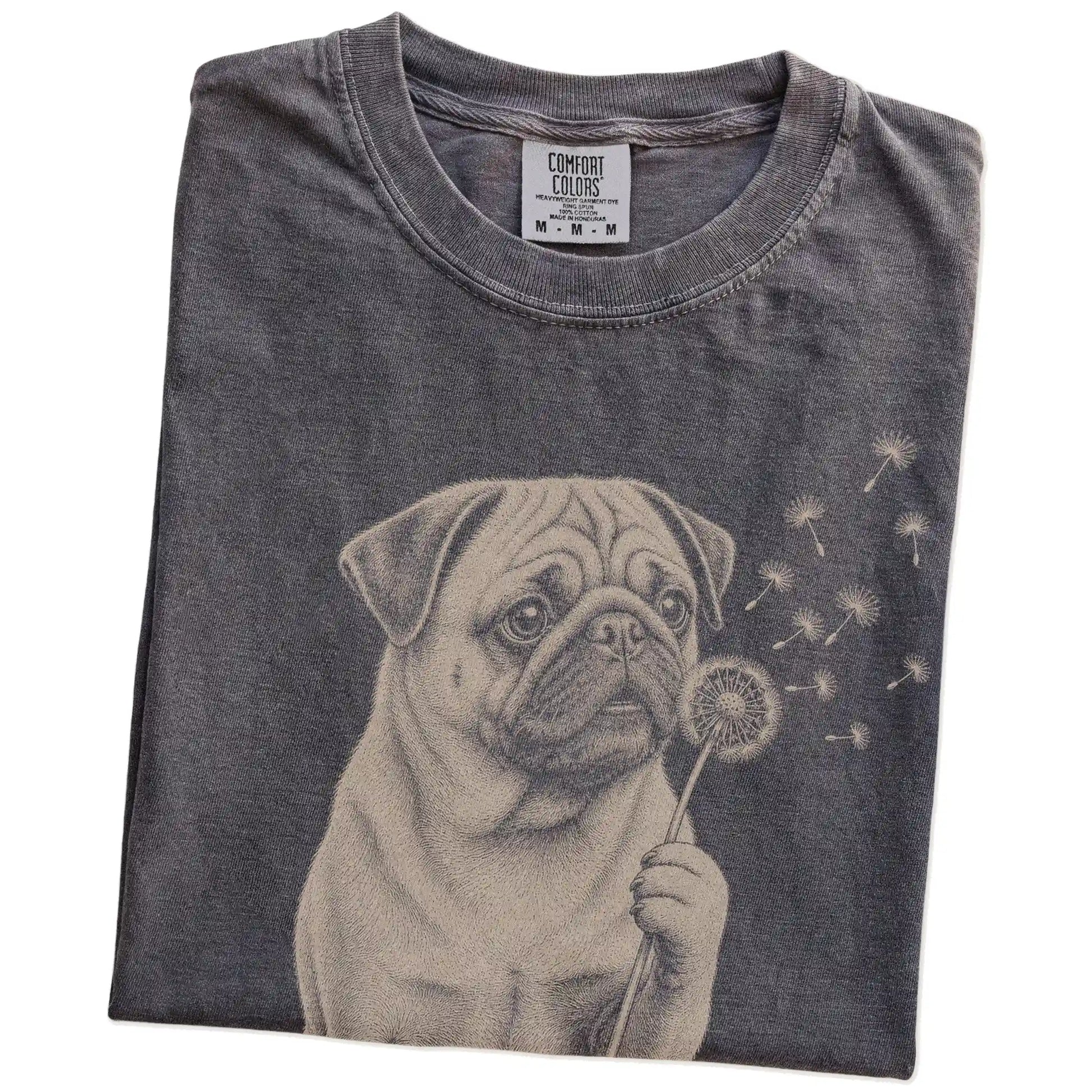 Folded Pepper Comfort Colors® T-shirt showing Pug portrait with drifting dandelion seeds