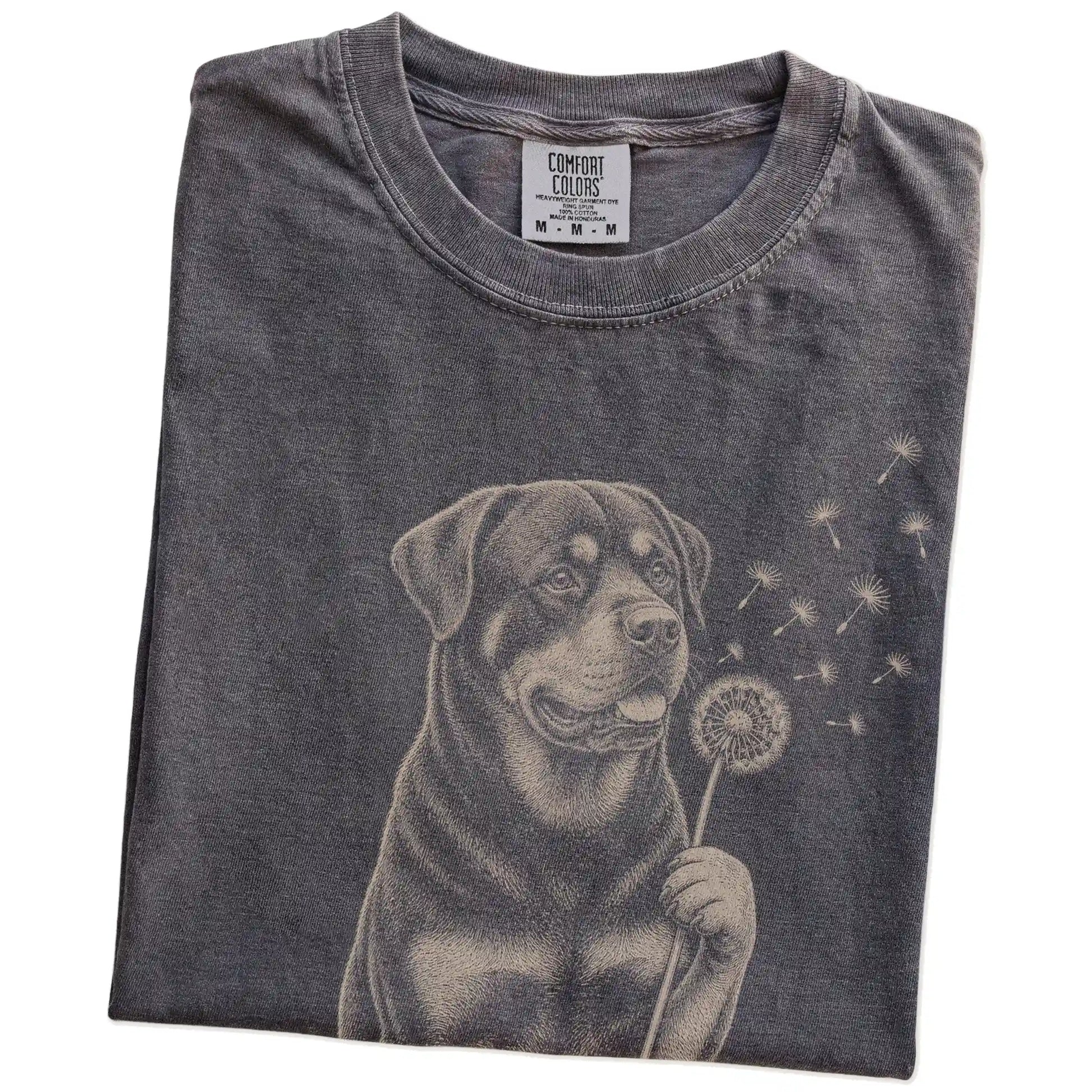 Folded Pepper Comfort Colors® T-shirt showing Rottweiler portrait with drifting dandelion seeds