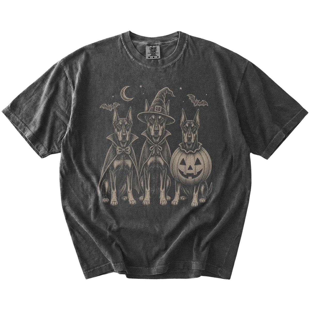 Three Doberman dogs dressed for Halloween beneath bats and a crescent moon on a Pepper Comfort Colors® T-shirt