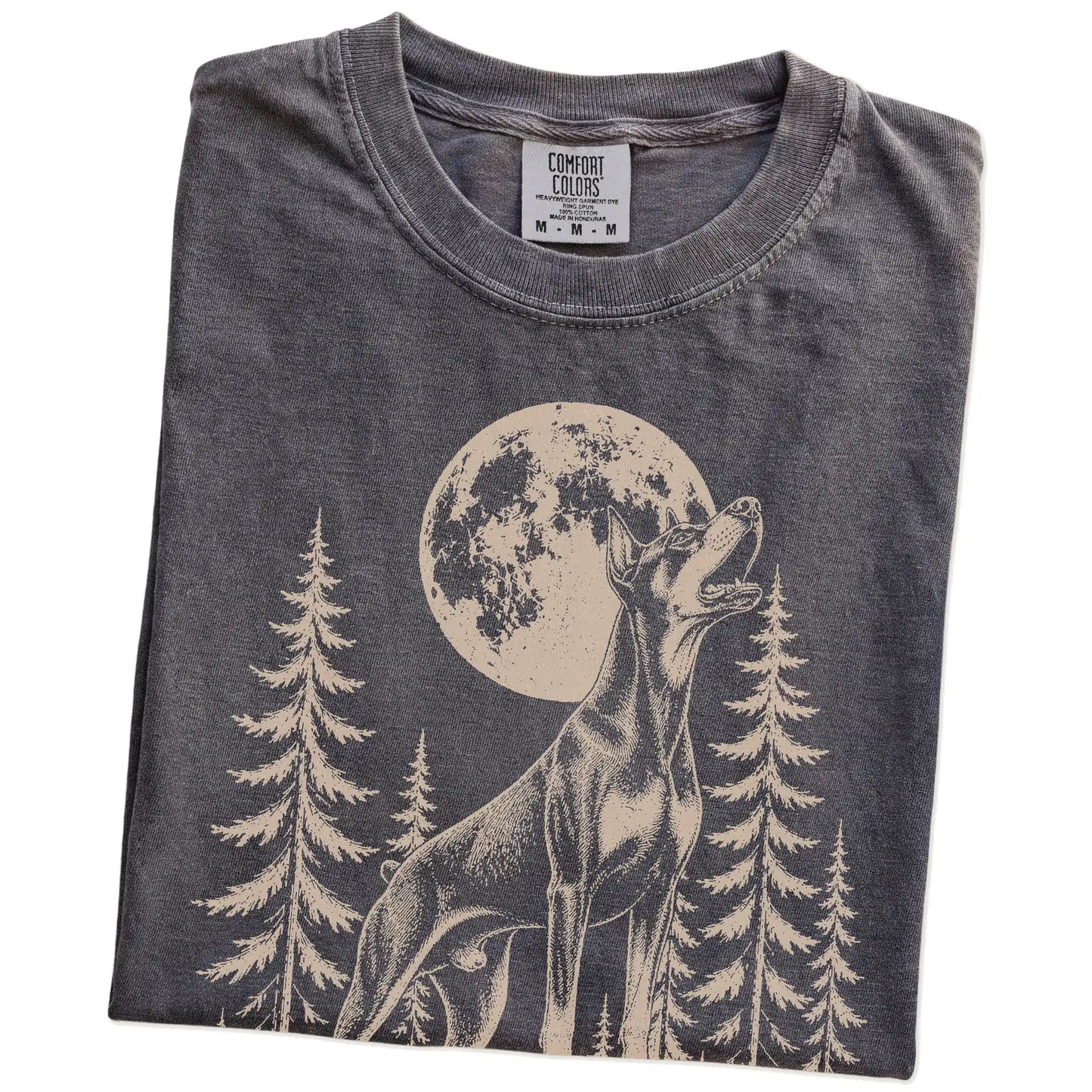 Folded Pepper Comfort Colors® T-shirt showing a Doberman howling beneath the moon and pine trees