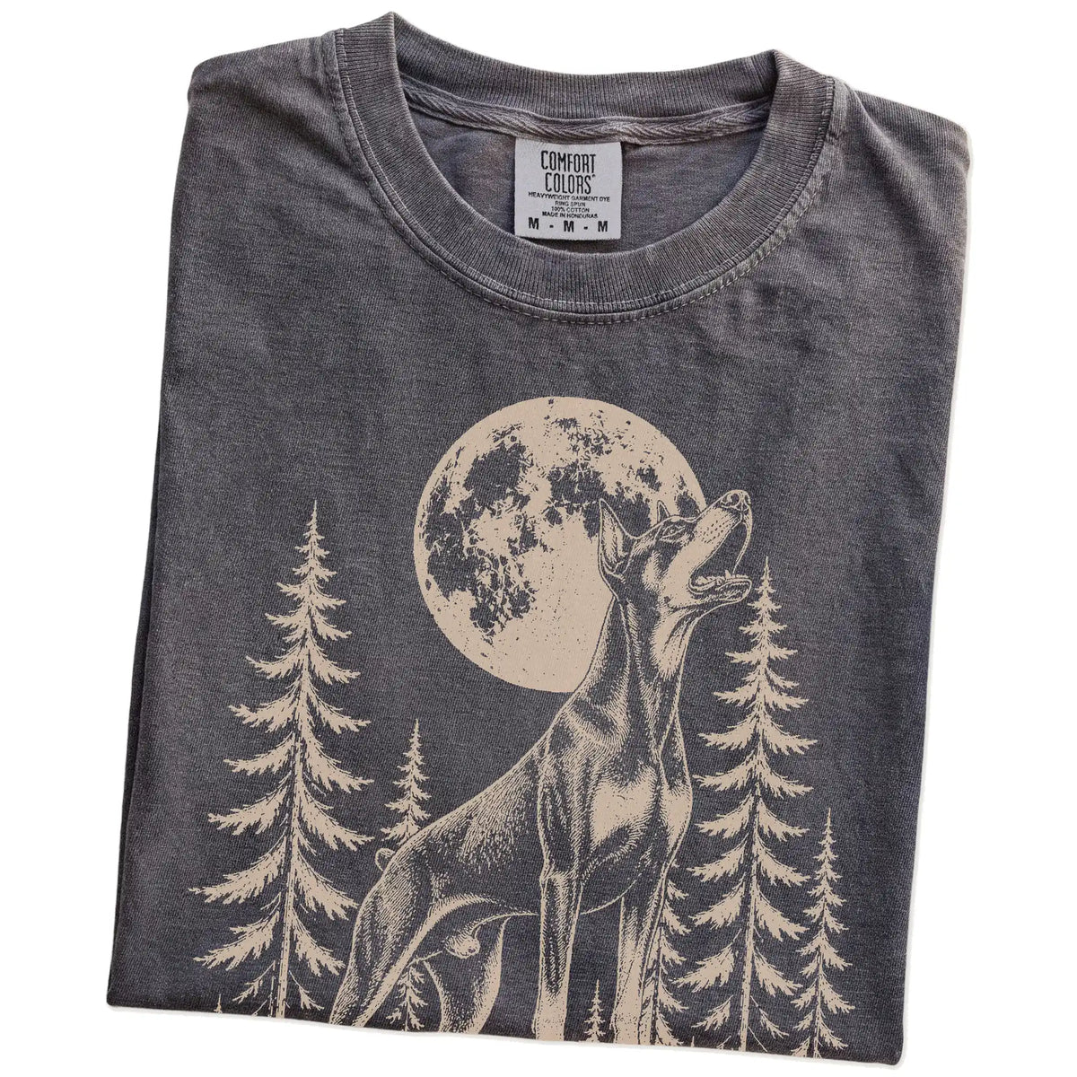 Folded Pepper Comfort Colors® T-shirt showing a Doberman howling beneath the moon and pine trees