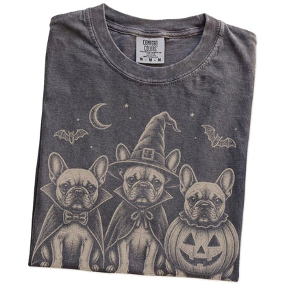 Folded Pepper Comfort Colors® T-shirt showing three French Bulldog dogs dressed for Halloween beneath bats and a crescent moo