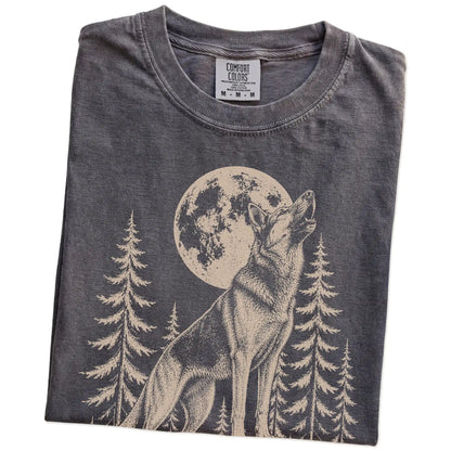 Folded Pepper Comfort Colors® T-shirt showing a German Shepherd howling beneath the moon and pine trees
